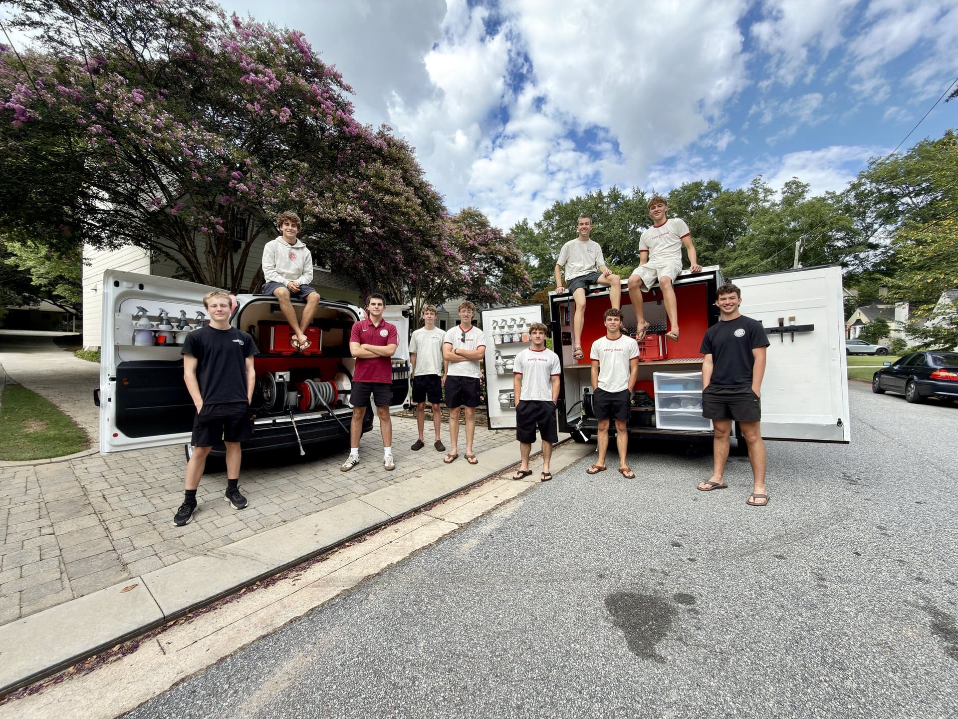 Every Detail team gathered with the company mobile detailing rigs